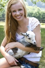 Teenage girl (14-15) holding small goat. Photo: Pauline St.Denis