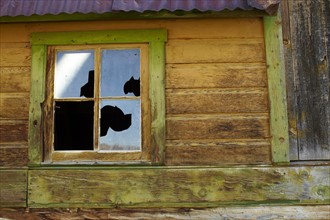 USA, Colorado, Abandoned log cabin with broken window. Photo: John Kelly