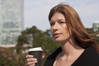 The Netherlands, Amsterdam, Portrait of businesswoman with coffee. Photo: Jan Scherders