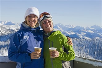 USA, Montana, Whitefish, Portrait of two women with mountains as backdrop. Photo: Noah Clayton