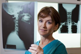 Portrait of female doctor looking at x-ray. Photo: db2stock