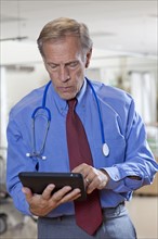 Doctor using digital tablet in hospital. Photo : db2stock