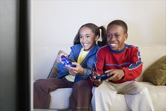 Brother and sister (10-13) playing video game. Photo: Rob Lewine