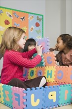Girls (6-7) playing with puzzle letters. Photo: Rob Lewine