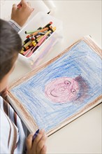 Boy (6-7) drawing in classroom. Photo : Rob Lewine