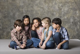 Children (6-7, 8-9) comforting fiend, studio shot. Photo: Rob Lewine