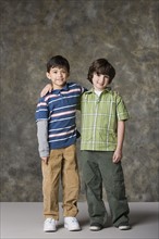 Two boys (6-7, 8-9) standing together, studio shot. Photo : Rob Lewine