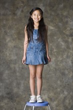 Portrait of standing smiling girl (8-9), studio shot. Photo : Rob Lewine