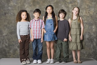 Children (6-7, 8-9) standing together with eyes closed, studio shot. Photo : Rob Lewine