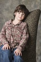 Portrait of smiling (6-7) boy, studio shot. Photo : Rob Lewine