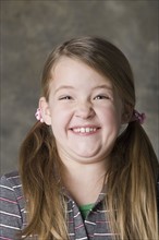 Portrait of smiling girl (8-9), studio shot. Photo: Rob Lewine