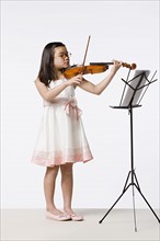 Girl (8-9) playing violin, studio shot. Photo: Rob Lewine