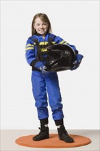 Portrait of girl (8-9) dressed as racing driver, studio shot. Photo : Rob Lewine