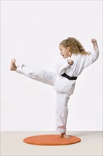 Girl (8-9) training martial arts, studio shot. Photo: Rob Lewine