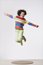 Studio portrait of jumping girl (8-9). Photo : Rob Lewine