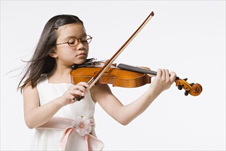 Studio portrait of girl (8-9) playing violin. Photo : Rob Lewine