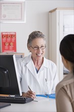 Smiling female doctor talking to patient in her office. Photo: Rob Lewine