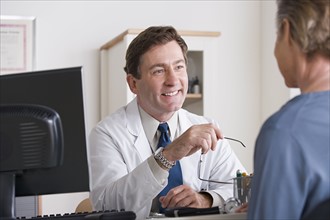 Male doctor talking to patient in his office. Photo : Rob Lewine