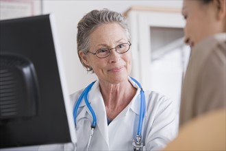 Smiling female doctor talking to patient in her office. Photo: Rob Lewine