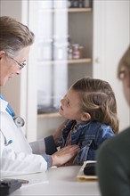 Female doctor talking to small girl (4-5) in her office. Photo : Rob Lewine