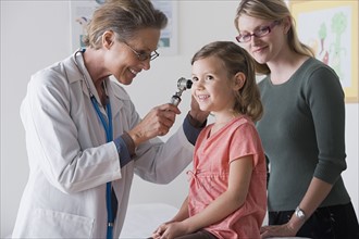 Female doctor examining small girl (4-5). Photo : Rob Lewine
