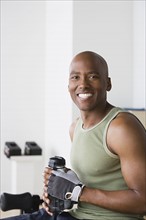 Portrait of smiling young man in gym. Photo : Rob Lewine