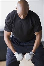 Man weighting dumbbells. Photo : Rob Lewine