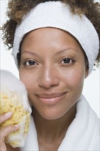 Portrait of attractive woman holding bath sponge. Photo: Rob Lewine