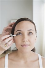 Woman having make-up applied. Photo : Rob Lewine