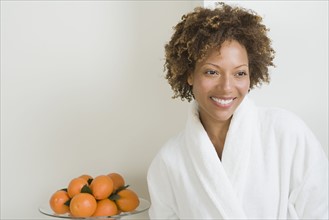 Portrait of attractive woman with oranges in bowl. Photo : Rob Lewine