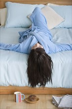 Woman lying on bed. Photo: Rob Lewine