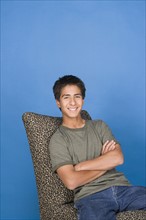 Portrait of teenage boy (16-17) sitting in chair. Photo : Rob Lewine