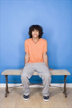 Portrait of teenage boy (14-15) sitting on bench. Photo : Rob Lewine