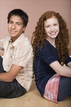 Portrait of teenage (16-17) girl and teenage boy (16-17) sitting together. Photo : Rob Lewine