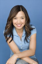 Portrait of happy asian woman wearing blue polo shirt. Photo : Rob Lewine