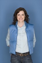 Portrait of happy mid adult woman wearing blue vest. Photo : Rob Lewine