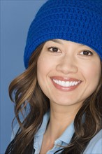Portrait of happy asian woman wearing blue knit hat. Photo : Rob Lewine