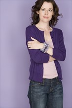Portrait of smiling woman on purple background, studio shot. Photo : Rob Lewine