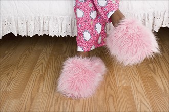 Close up of girl's (10-11) legs in pajamas and slippers. Photo: Rob Lewine