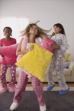 Portrait of three girls (10-11) jumping at slumber party. Photo : Rob Lewine