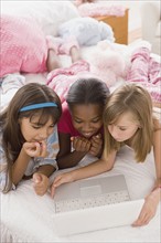 Portrait of three girls (10-11)using laptop. Photo : Rob Lewine