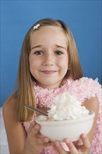 Portrait of girl (10-11) holding bowl with whipped cream. Photo : Rob Lewine