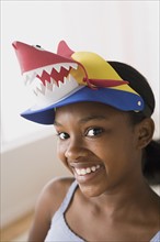 Portrait of smiling girl (10-11) wearing funny hat. Photo : Rob Lewine