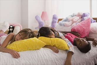Three girls (10-11) sleeping on bed at slumber party. Photo: Rob Lewine