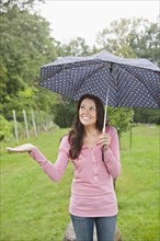 USA, New Jersey, Portrait of woman holding umbrella. Photo: Tetra Images