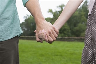 Close-up of couple holding hands. Photo : Tetra Images