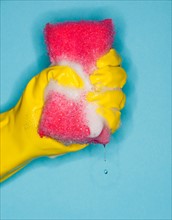 Hand in glove squeezing sponge.