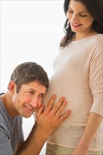 Man putting ear to pregnant woman's belly.