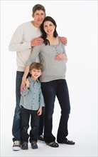 Studio portrait of father, pregnant mother and son (4-5).