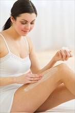 Woman applying moisturizer.
